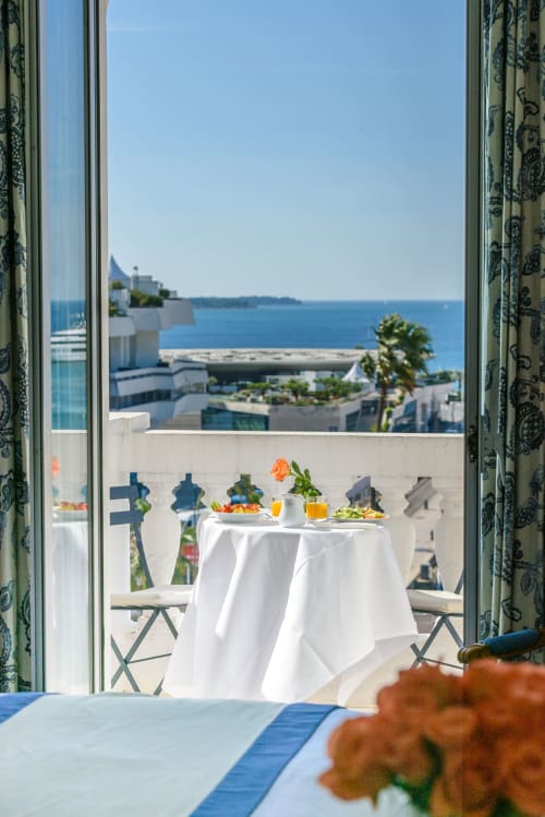 Elegante tavolo in balcone con tovaglia bianca e bevande con vista sul Mar Mediterraneo all'Hotel Splendid Cannes