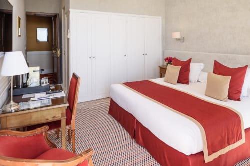 Camera superiore di lusso con vista mare all'Hotel Splendid Cannes, biancheria rossa e bianca, arredamento elegante e moderno