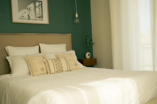 Chambre Tramontane de La Maison du Potier à Valras-Plage avec murs verts et literie crème
