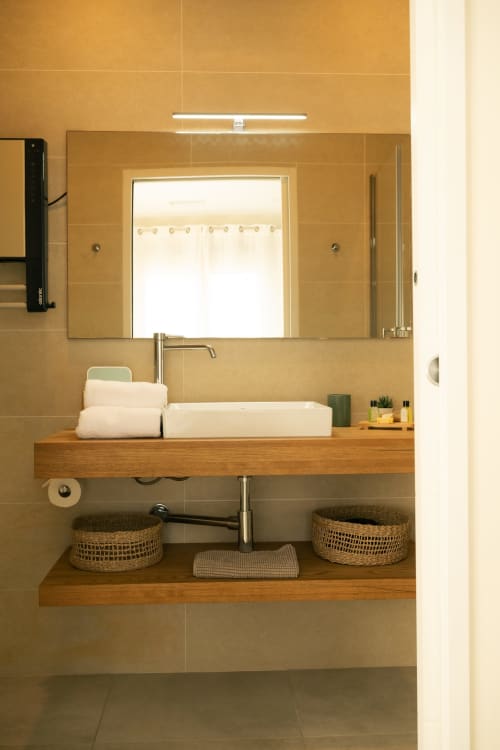 Salle de bains moderne à La Maison du Potier avec meuble-lavabo en bois, vasque blanche et grand miroir