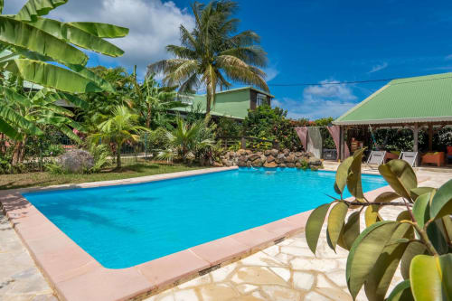 Piscine bleu cristal de la villa Bagatelle à Sainte-Rose, Guadeloupe, entourée de plantes tropicales et d'espace détente