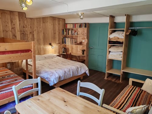Chambre familiale spacieuse à La Petite étoile B&B avec lits en bois, armoire verte, rangements et décor rustique