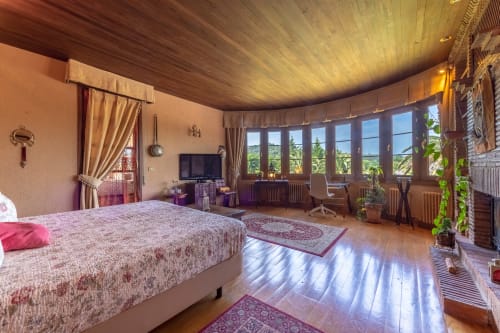 Suite Real espaciosa en Palacio Vasco con techo de madera, cama grande, vistas al jardín desde ventanas y comodidades modernas