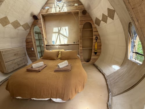 Chambre Le Nid Marin au Patio aux Oiseaux B&B à La Ciotat avec intérieur en bois courbe, lit aux draps dorés et jardin