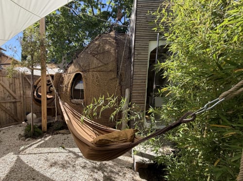 Jardin intime au Patio aux Oiseaux avec hamac et chaise-pod tressée entourés de verdure luxuriante à La Ciotat
