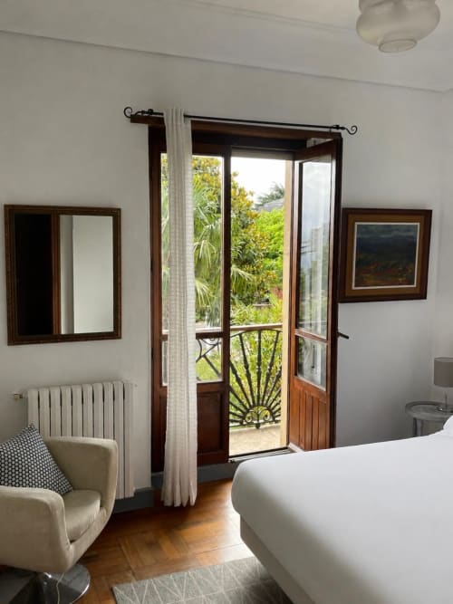 Elegant bedroom at Casa Señorial Sasueta with French doors opening to garden balcony in San Sebastián