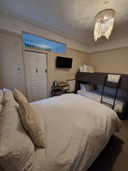 Blacksheep Lodge Standard Family Room in Holyhead with queen bed, bunk beds, TV, and cream furnishings