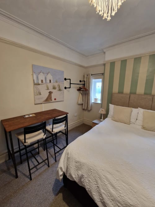 Standard Family Room at Blacksheep Lodge in Holyhead with bed, desk, striped wallpaper, and beach-themed artwork
