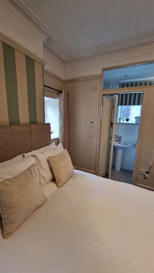 Standard Family Room at Blacksheep Lodge Holyhead, with bed, ensuite bathroom, and striped curtains