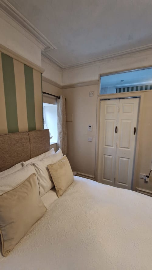 Standard Family Room at Blacksheep Lodge Holyhead with bed, striped headboard, wardrobe, and window