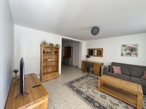 Spacieux séjour de l'Appartement Foix au Domaine de Bize Mirepoix avec mobilier en bois, canapé gris et équipements modernes