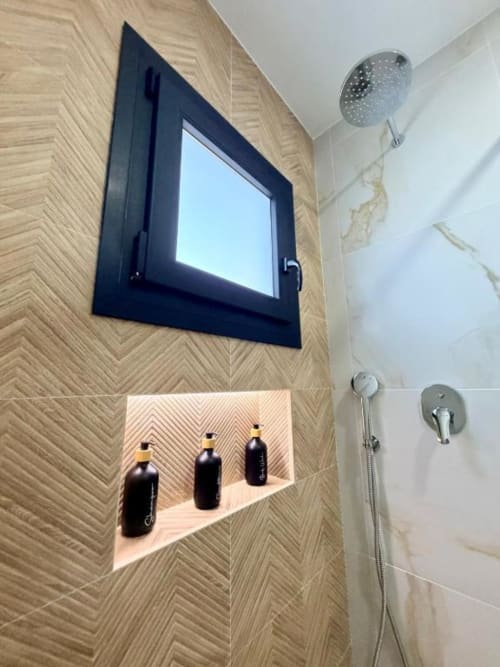 Área de ducha moderna en villa Barrosa Home con paredes de azulejos en espiga, espejo con marco negro, alcachofa de lluvia y