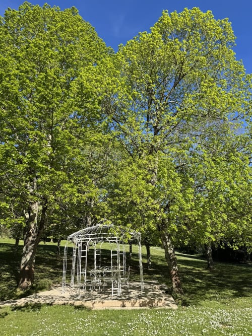 Petit pavillon blanc entouré de verdure luxuriante au printemps au Domaine de Bize, Mirepoix, Ariège