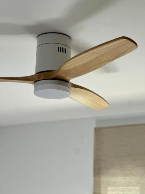 Ventilador de techo moderno con aspas de madera y motor gris instalado en Villa Faro de Barrosa Home, Hozanejos