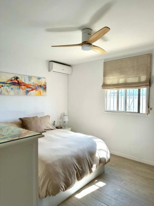 Luminosa habitación en Villa Faro de Barrosa Home, Hozanejos, con ventilador de madera, cama, aire acondicionado y ventana con vista al jardín