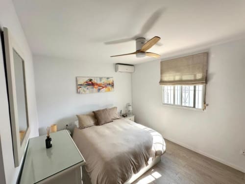 Dormitorio moderno en villa Barrosa Home con ventilador de techo, cama, escritorio, ventana con vista al jardín y aire acondicionado en Hozanejos