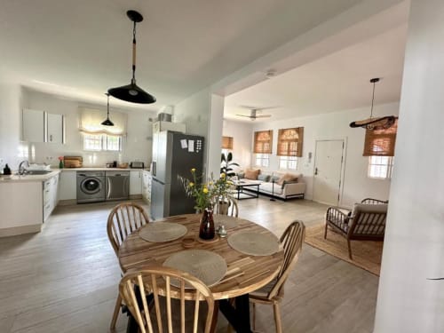 Cocina y comedor de villa moderna en Barrosa Home, Hozanejos, con mesa de madera, electrodomésticos y sala de estar abierta
