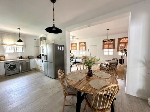 Cocina y comedor modernos en Villa Faro, Hozanejos, con mesa de madera, electrodomésticos de acero inoxidable y salón abierto