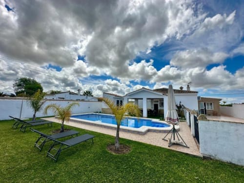 Villa Faro en Hozanejos con piscina privada, tumbonas, palmeras y jardín cuidado bajo cielo azul
