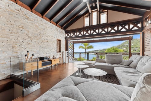 Salon moderne de la villa Les Balcons D'Oyster Pond, Saint-Martin, avec sièges gris, mobilier bois et accent brique