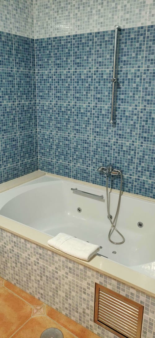 Lujosa bañera de hidromasaje con azulejos de mosaico azul en Hotel La Posada España