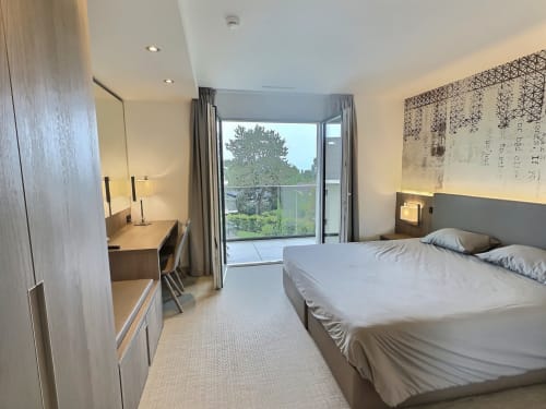 Chambre moderne aux Résidences Attica à St-Sulpice avec vue sur le lac, bureau et télévision écran plat