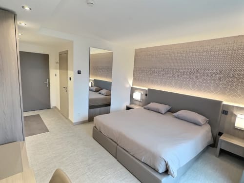 Chambre moderne aux Attica Résidences à St-Sulpice avec lit queen-size, miroir, bureau et éclairage ambiant