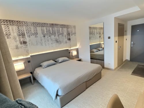 Chambre moderne aux Attica Résidences à St-Sulpice avec lit queen, tête de lit décorée, miroir et design contemporain