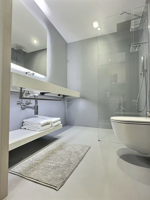 Salle de bains moderne aux Résidences Attica St-Sulpice avec lavabo blanc, cabine de douche et radiateur sèche-serviettes
