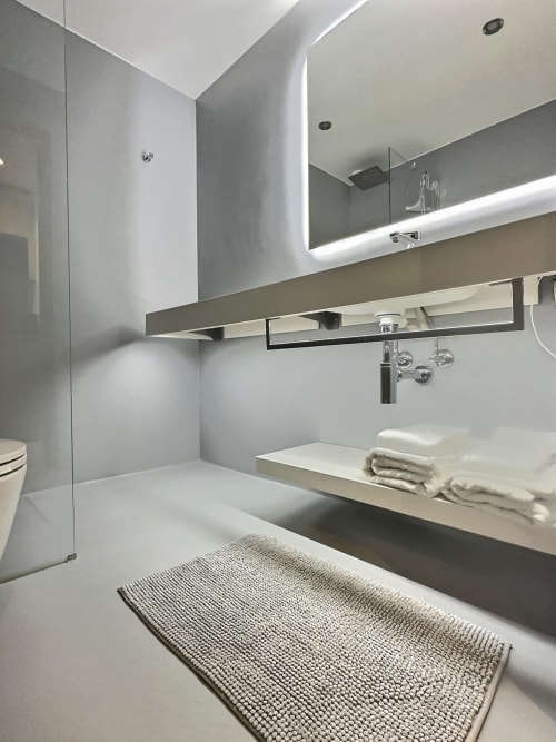 Salle de bain moderne aux Résidences St-Sulpice : vasque suspendue, miroir illuminé, douche et décoration épurée