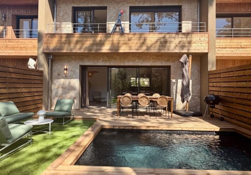 Cour privée de la Villa Benedettu avec piscine, coin repas, transats et architecture contemporaine à Porto-Vecchio