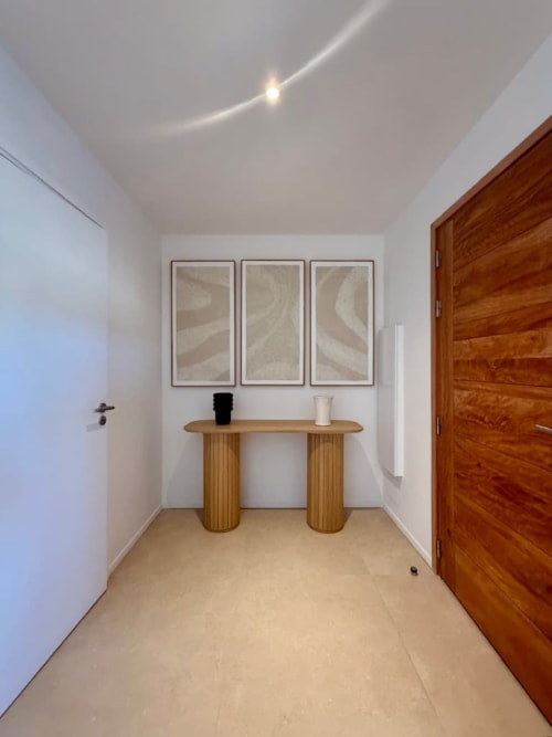 Couloir contemporain de la Villa Benedettu aux Villas d'A Storia avec console en bois et tableaux encadrés à Porto-Vecchio