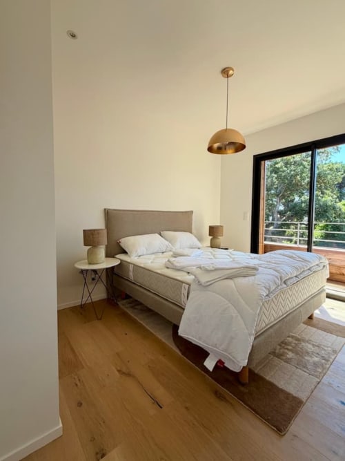 Chambre moderne aux Villas d'A Storia à Porto-Vecchio avec lit, suspension et balcon vue mer