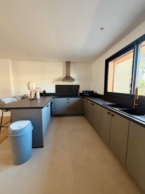 Cuisine ouverte moderne de la Villa San Ciprianu aux Villas d'A Storia, Porto-Vecchio, avec plans de travail noirs et grandes