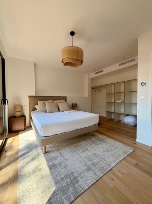 Chambre moderne de la Villa San Ciprianu aux Villes d'A Storia, Porto-Vecchio, avec lit en bois, luminaire suspendu et rangements