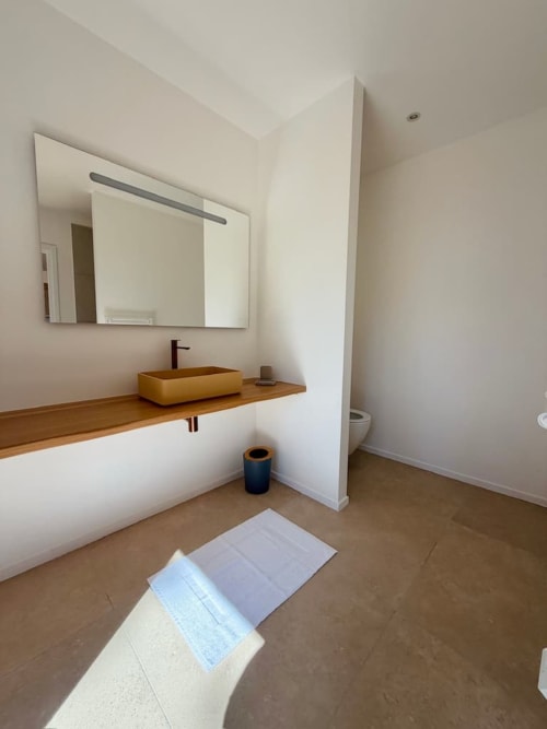 Salle de bain moderne de la Villa Cala Rossa aux Villas d'A Storia, Porto-Vecchio, avec meuble-lavabo en bois et lavabo jaune
