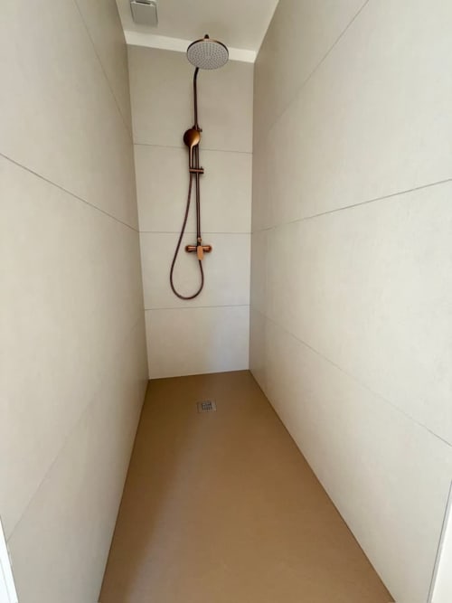 Salle de bains moderne avec tête de douche pluie et robinetterie bronze à la villa Les Villas d'A Storia à Porto-Vecchio