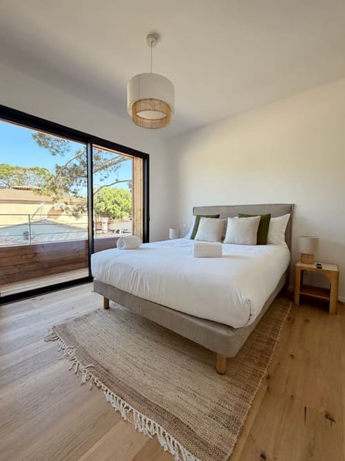 Chambre moderne avec vue sur la piscine aux Villas d'A Storia à Porto-Vecchio, lit garni de coussins et terrasse privée
