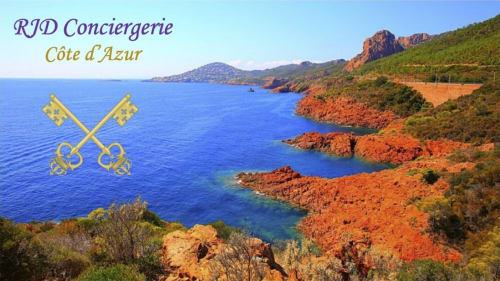 Vue côtière de la Conciergerie RJD Côte d'Azur avec eaux méditerranéennes turquoise, falaises rouges et végétation verdoyante