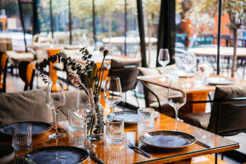 Mise en place élégante chez Business Apparts Caudry avec verres de vin, couverts et fleurs séchées sur tables en bois