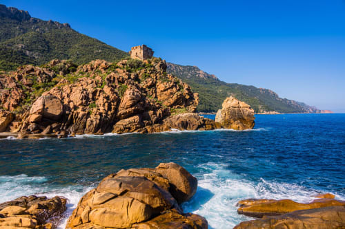Falaises rocheuses côtières avec tour dominant les eaux turquoise de la Méditerranée près de Porto-Vecchio, Corse