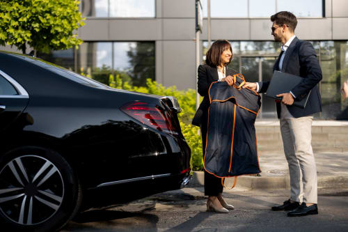 Professionnels d'affaires effectuant une transaction près d'une voiture noire à RJD Conciergerie Côte d'Azur à Sainte-Lucie-de-Porto-Vecchio