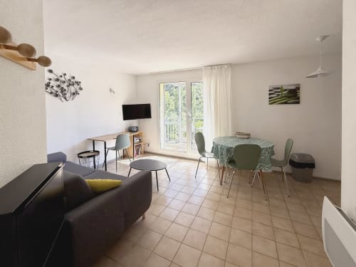 Séjour moderne à LOCADIGNE à Digne-les-Bains : canapé, table à manger, bureau, téléviseur et vue sur les montagnes