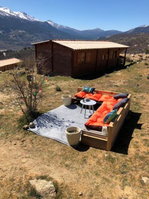 Salon extérieur aux Chalets de Lozzi à Calacuccia avec vue montagne et chalet en bois