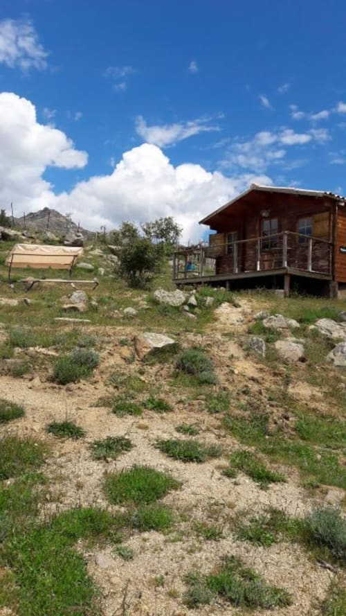Chalet rustique en bois avec terrasse surplombant le paysage de Calacuccia, entouré de végétation méditerranéenne