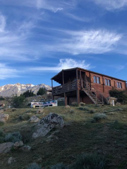 Chalet en bois rustique à Calacuccia avec vue sur les montagnes, terrasse et jardin face aux pics enneigés sous ciel bleu