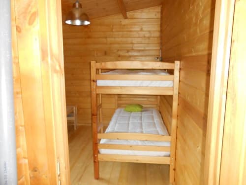 Lits superposés en bois avec matelas blancs dans une chambre rustique aux Chalets de Lozzi, Calacuccia
