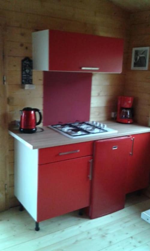 Cuisine rouge et blanche avec cuisinière à gaz, bouilloire et cafetière au chalet deux chambres des Chalets de Lozzi, Calacuccia