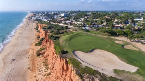 Campo de golfe à beira-mar em Portugal com falésias vermelhas, praia e Mar Mediterrâneo na Timeless Vacations