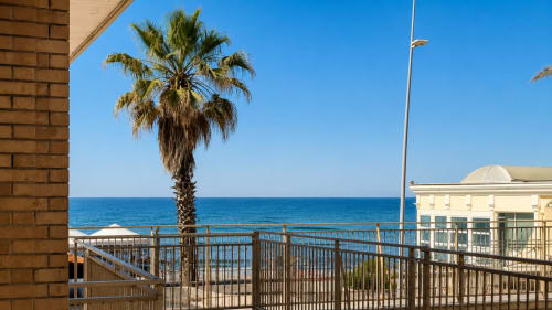 Vista dal balcone Oceanine 7 dell'hotel ViOletta a Lido di Ostia con vista mare, palme e la costa azzurra del Mediterraneo